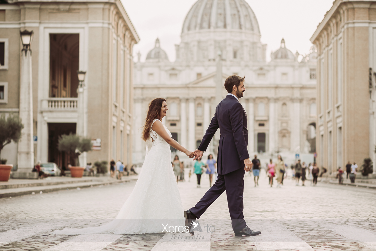 Paseo romántico de novios en su postboda por la plaza de San Pedro de Roma